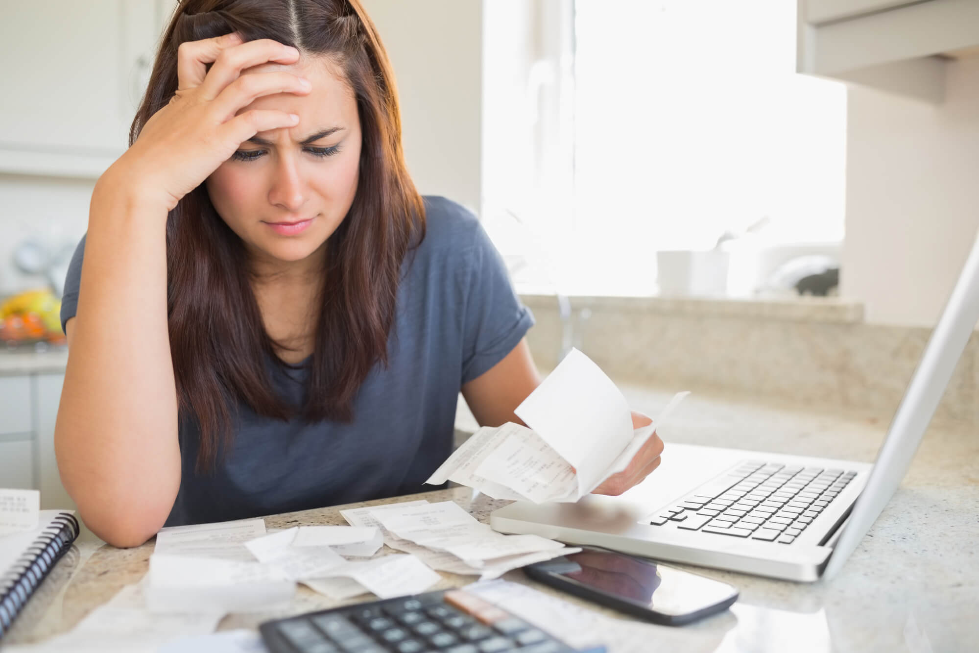 Hero Image of Woman holding receipts and being stressed at her computer