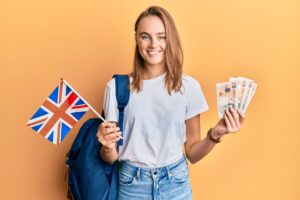Young Woman Student holding UK flag and pounds